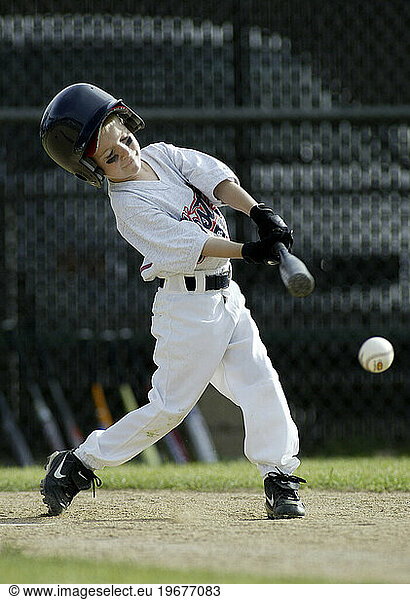 Young boy playing baseball in uniform.
