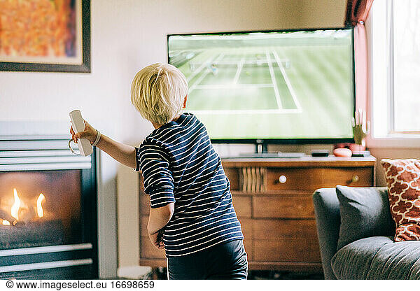 Young boy playing video games on tv