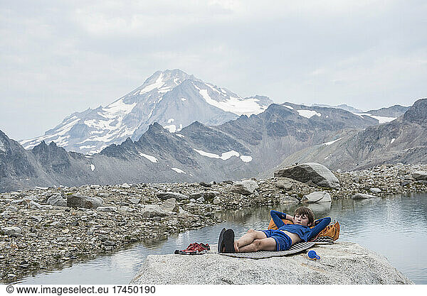 Young boy relaxes while hiking in Glacier Peak wilderness area