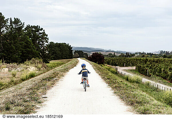 Young boy riding a bike on remote path in New Zealand