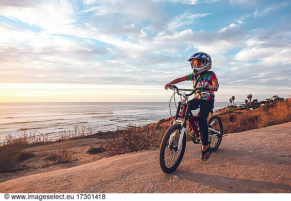 Young boy riding his bike on a coastal trail