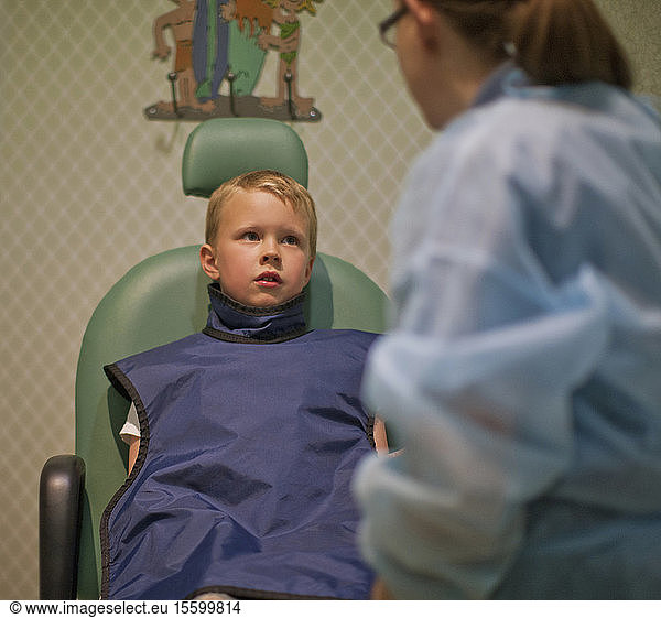 Young boy sitting in a chair at a dental office