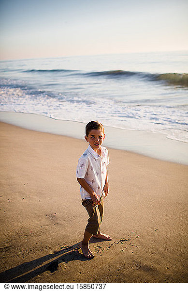 Young Boy Standing on Beach at Sunset