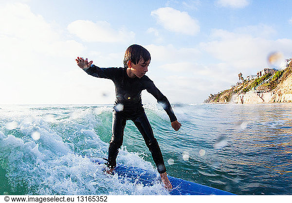 Young boy surfing wave  Encinitas  California  USA
