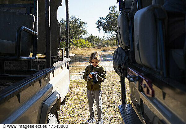 young boy with camera on safari  Okavango Delta  Botswana
