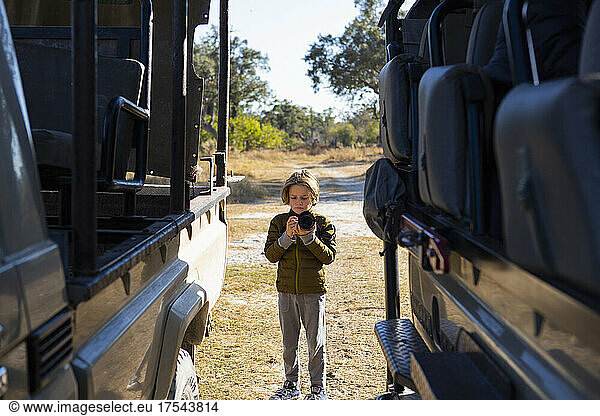 young boy with camera on safari  Okavango Delta  Botswana