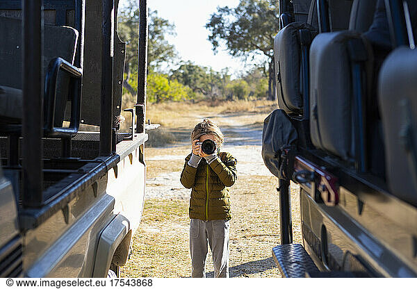 young boy with camera on safari  Okavango Delta  Botswana