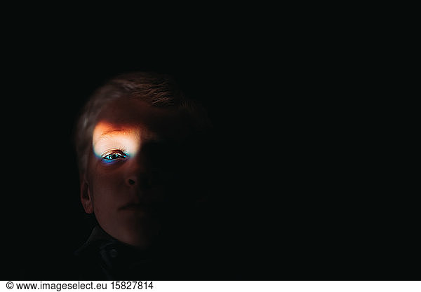 young boy with rainbow flare on eye