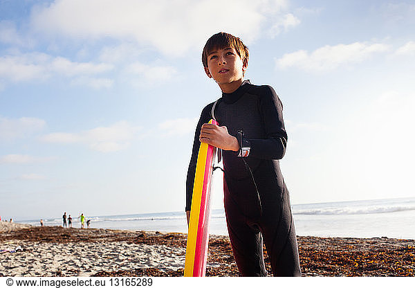 Young boy with surfboard on beach  Encinitas  California  USA