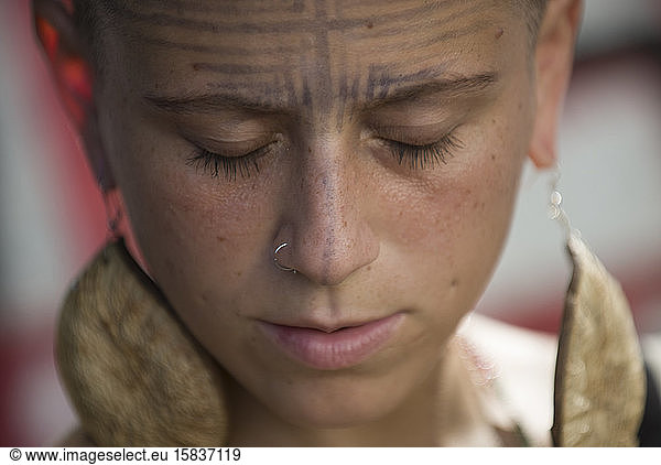 Young Brazilian woman with indigenous earrings and face painting