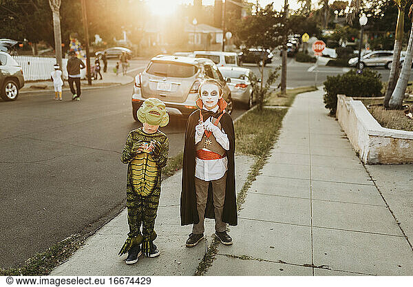 Young brothers dressed in costumes Trick-or-Treating on Halloween