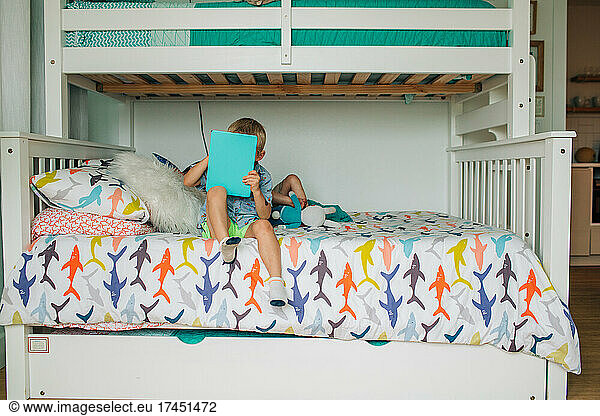 Young brothers relax on bunk beds in rental house on vacation