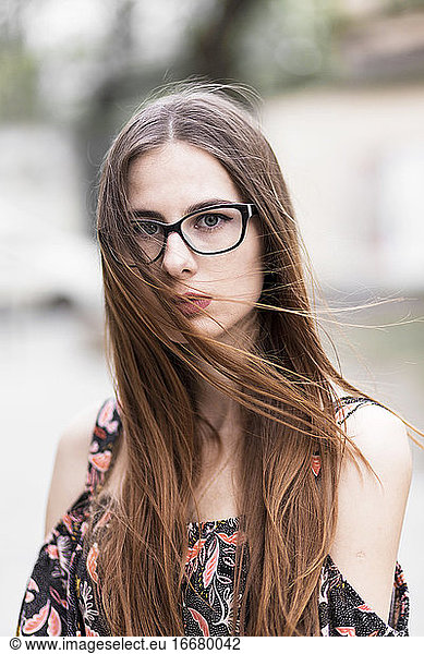 young brown-haired millennial with glasses and light dress