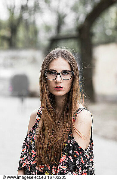 young brown-haired millennial with glasses and light dress