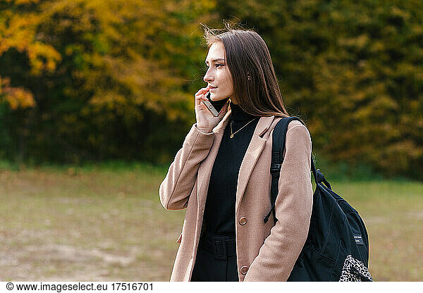 Young brunette girl talking on the mobile phone outdoor