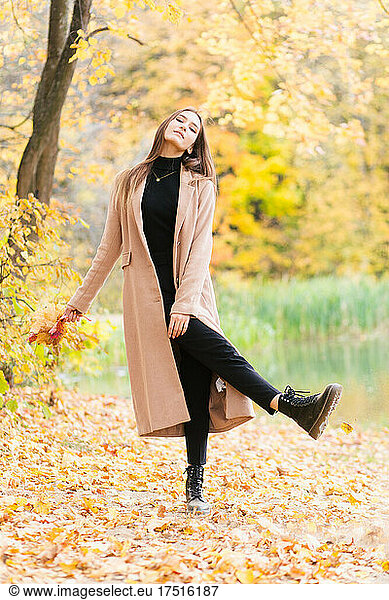 Young brunette girl walking in farest in autumn season