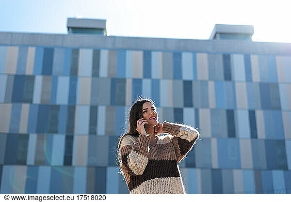 Young brunette woman happy while talking on her cell phone.
