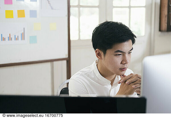 Young businessman analyze online marketing in his computer