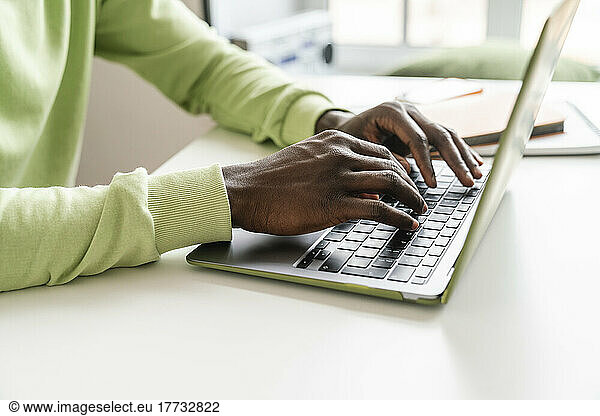 Young businessman typing on laptop at desk
