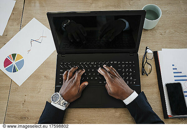 Young businessman typing on laptop working in office