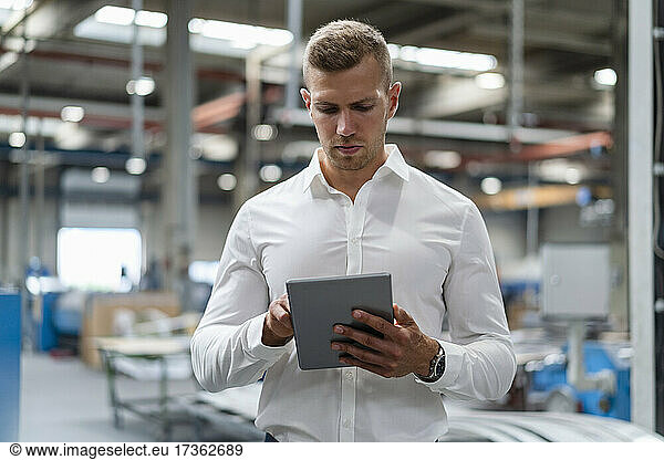 Young businessman using digital tablet at industry