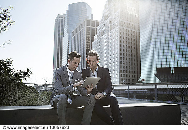 Young businessmen using tablet computer in city