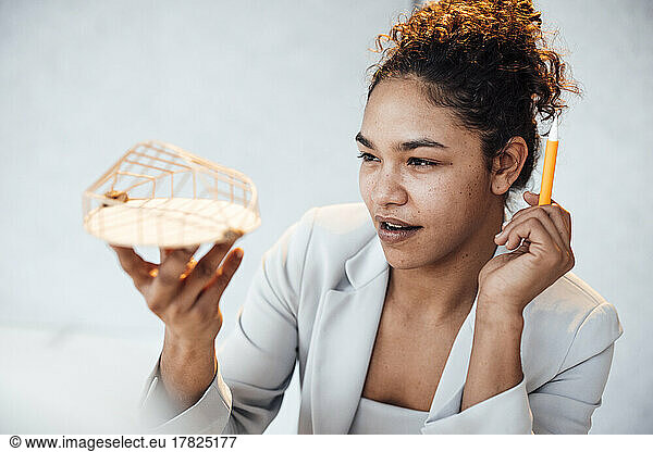 Young businesswoman examining architectural model