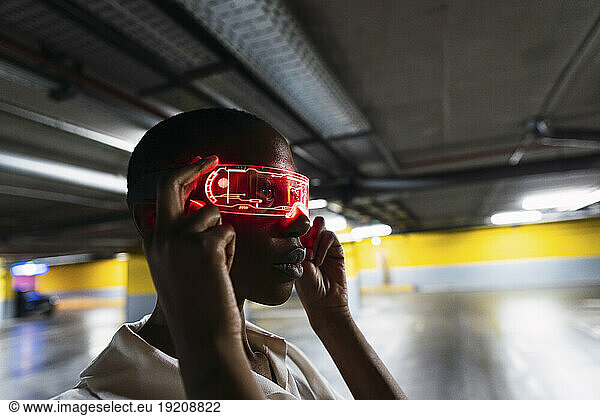 Young businesswoman holding smart glasses