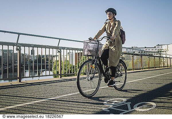 Young businesswoman riding cycle on bicycle lane while commuting to work