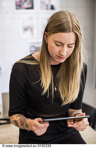 Young businesswoman using digital tablet in creative office
