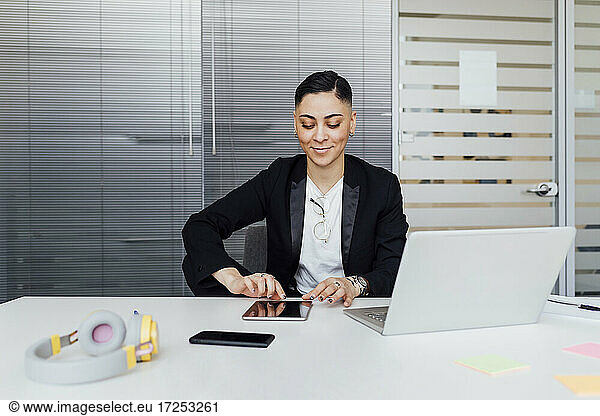 Young businesswoman using digital tablet while working at office