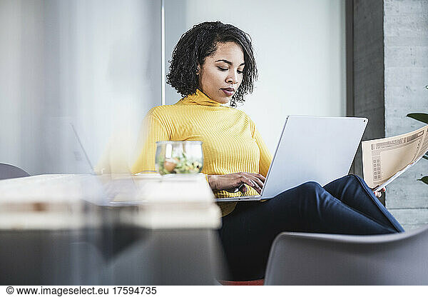 Young businesswoman using laptop at work place