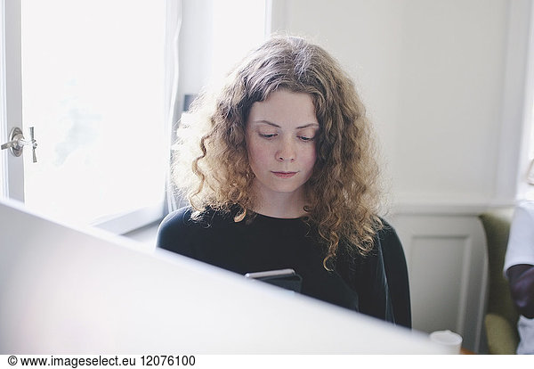 Young businesswoman using mobile phone in creative office