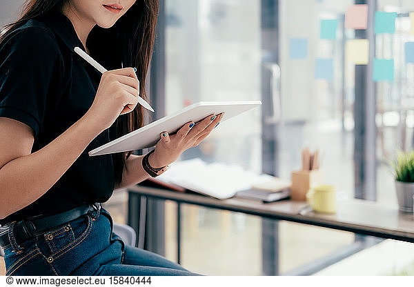 Young businesswoman using tablet searching infomation marketing