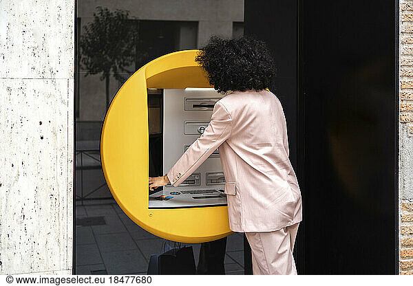 Young businesswoman using ticket machine