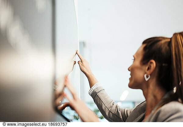 Young businesswoman using touch screen display at office