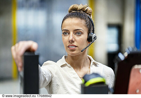 Young businesswoman with headset at warehouse
