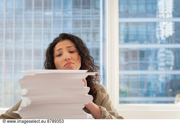 Young businesswoman with stack of paperwork