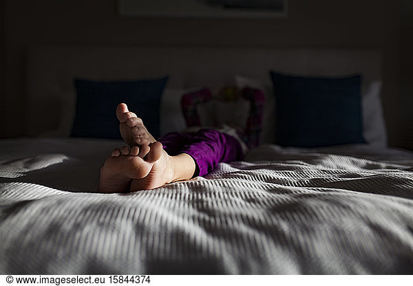 Young Child's Crossed Feet on Bed