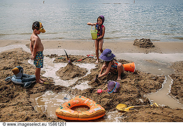 young children building sand castles on a beach in summer