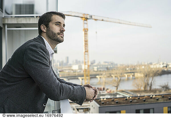 Young contractor standing with confidence on condo balcony