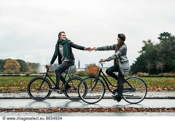 Young couple cycling on street