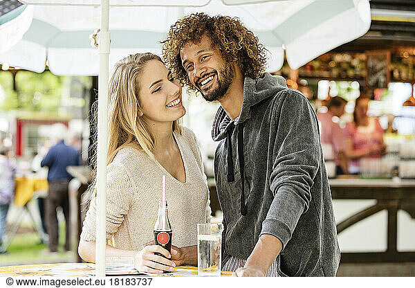 Young couple drinking beverage at a fun fair food stand