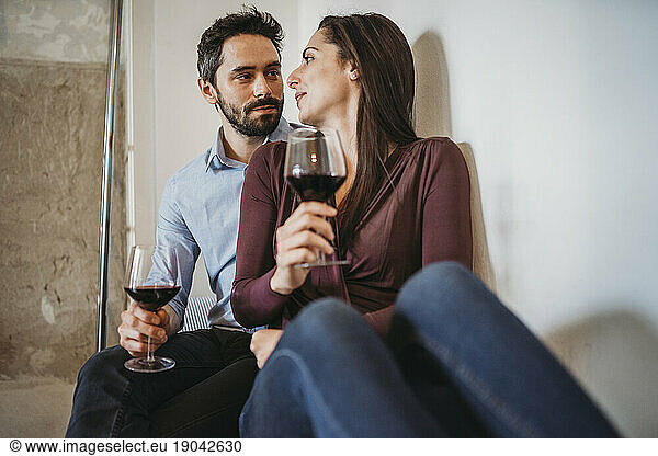 Young couple drinking red wine in a relaxing moment