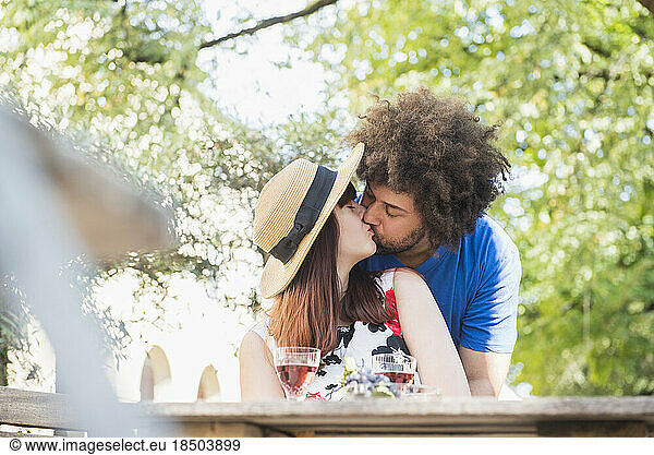 Young couple kissing at outdoor restaurant