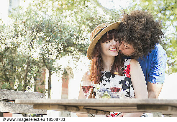Young couple kissing at outdoor restaurant