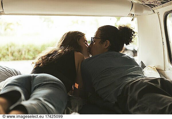 Young couple kissing each other in camping van