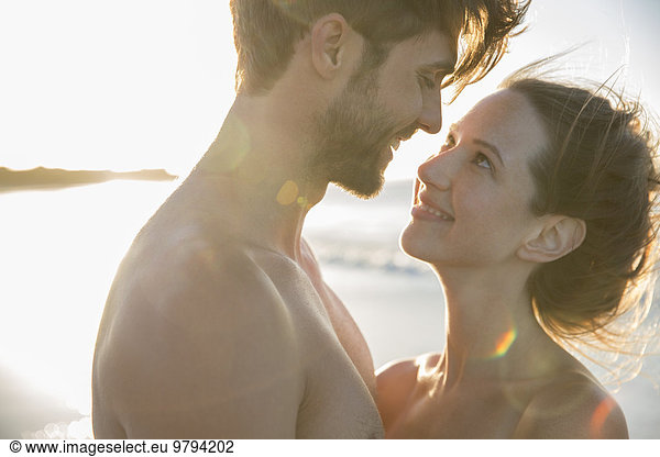 Young couple looking at each other on beach