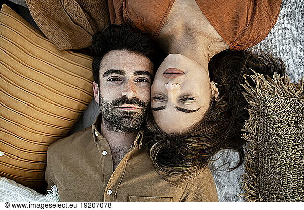 Young couple lying on picnic blanket