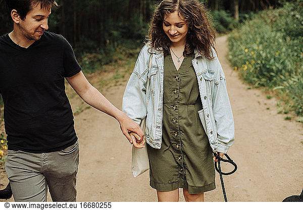 Young couple on first date holding hands while walking down the path